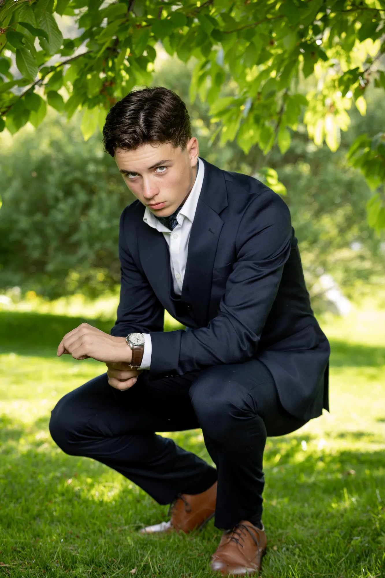 Konfirmant fotografert ved en værbitt tømmervegg, et sted som betyr noe